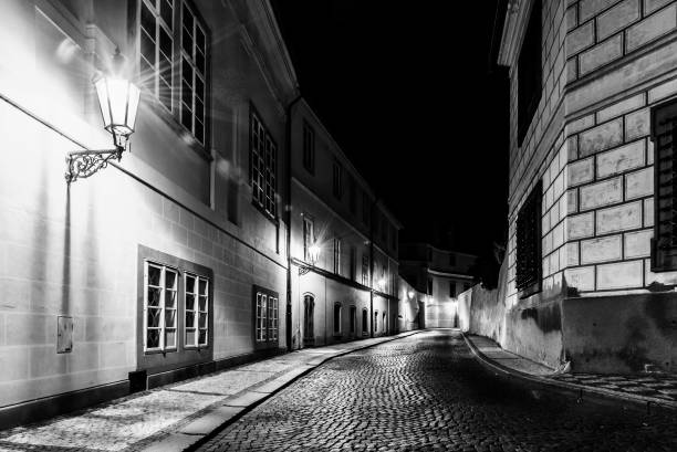 wąska brukowana ulica w starym średniowiecznym mieście z oświetlonymi domami przez zabytkowe lampy uliczne, novy svet, praga, czechy. nocny strzał - prague old door house zdjęcia i obrazy z banku zdjęć