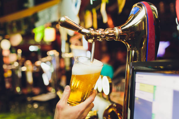 istock Barman hands pouring a lager beer in a glass. 1139370049