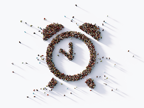 Human crowd forming an alarm clock symbol on white background. Horizontal  composition with copy space. Clipping path is included.