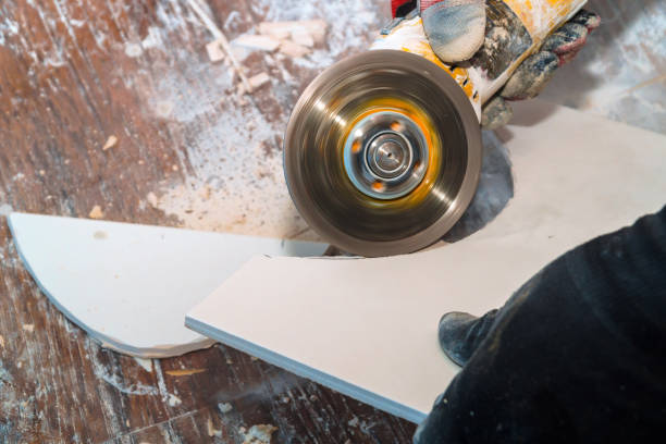 istock Worker cutting tile using grinder cut into layers of ceramic floor tiles 1139383657
