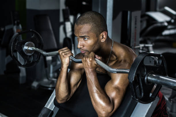 istock Man at the gym lifting weights and focused 1139386973