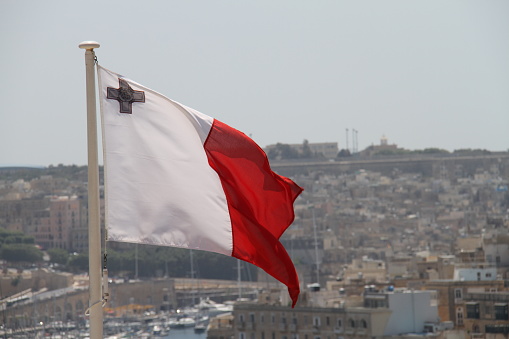 The flag of Malta in front of Valletta.