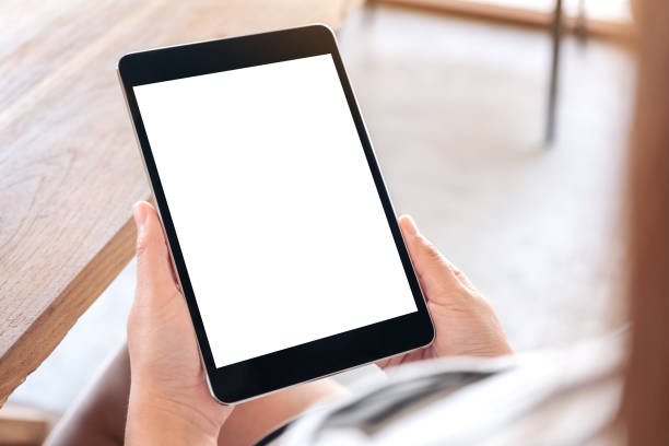 istock a woman sitting and holding black tablet pc with blank white desktop screen 1139400317