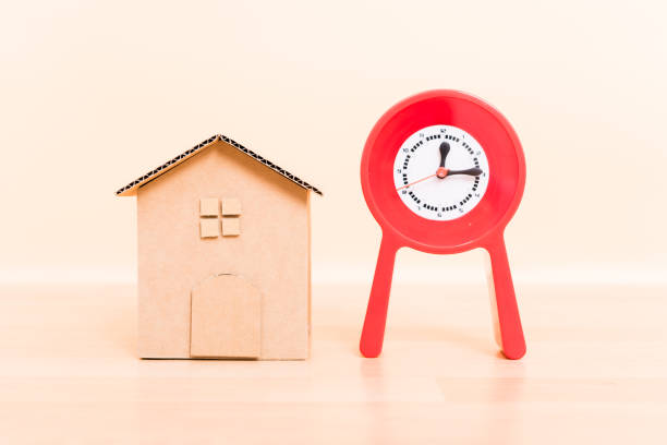 istock Cardboard paper model house and red clock 1139403747