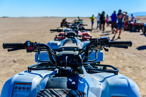 Unrecognizable people near quad bikes during safari trip in Arabian desert not far from Hurghada city, Egypt
