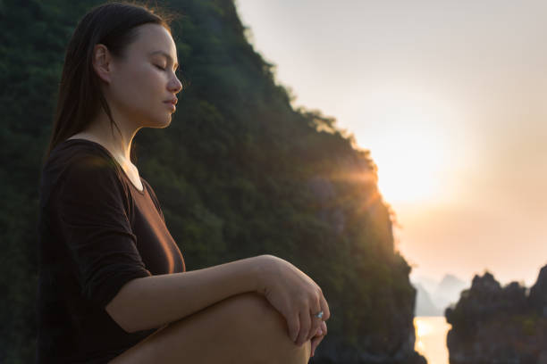 kobieta relaksująca i medytująca w przyrodzie, podczas zachodu słońca. spokojna zen. - spirituality yoga zen like meditating zdjęcia i obrazy z banku zdjęć