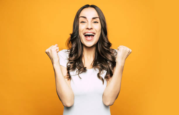Oh, yeah! Boffo, excited and very beautiful girl is sharing about something cool and showing it with the gestures of her hand and the mimic of her young face.
