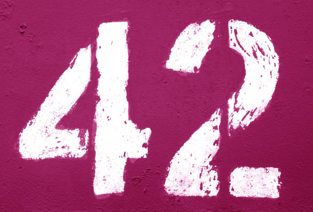 istock Number 42 in stencil on rusty metal wall in pink tone. 1139419287