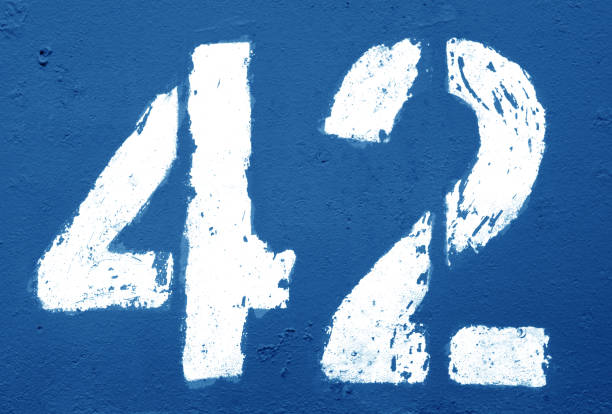 istock Number 42 in stencil on rusty metal wall in navy blue tone. 1139419538