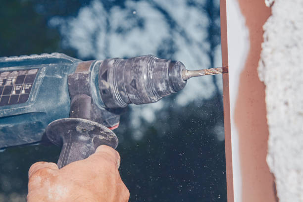 istock Worker using battery hand drill to screw into the PVC window frame. 1139419617