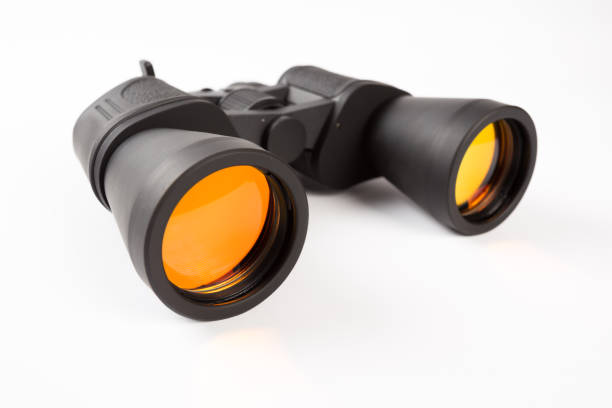 istock Black binoculars with orange lens isolated on white background 1139421575