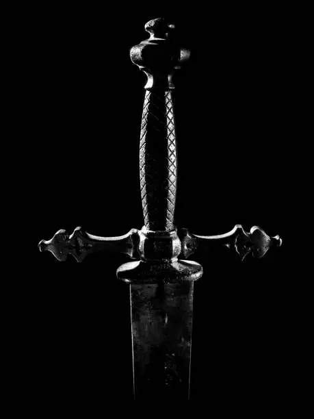Detail of medieval sword handle and guard with black background