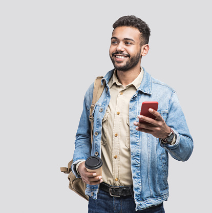 Studio shot of man going on a travel and holding smartphone.