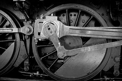Close-up of the wheel mechanics of an old steam locomotive - Monochrome