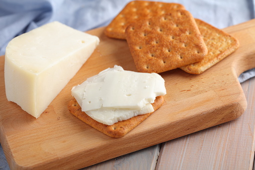 Crackers with Gouda Goat Milk Cheese on a wooden cutting board
