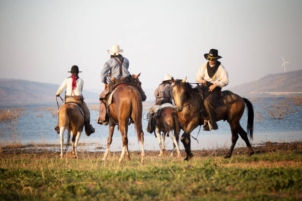 istock Men Riding Horse On Grass Against Lake And Sky 1139432842