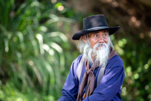 istock Man Wearing Hat Looking Away Against Trees 1139433150