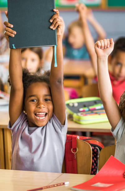 istock Joyful black student with raised arms in the classroom. 1139435668