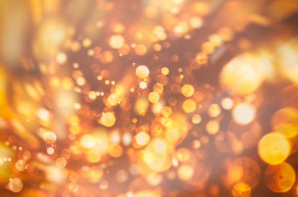 Golden soft focus bokeh blurred lights over a bright and shiny background. Great for creative projects and various designs, Christmas themed.