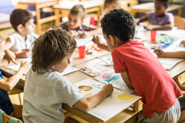 istock Group of elementary students having an art class in the classroom. 1139436429