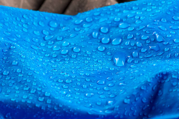 istock Nylon waterproof fabric with blurred foreground and background. Rain Drops on Water Resistant Textile waterproof coating background with water drops 1139440219