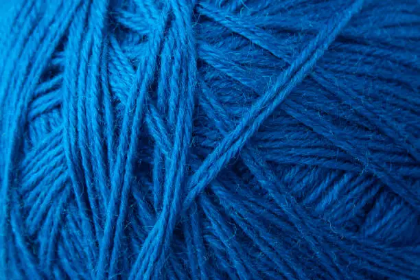 Blue yarn clew close up texture. Blue wool background