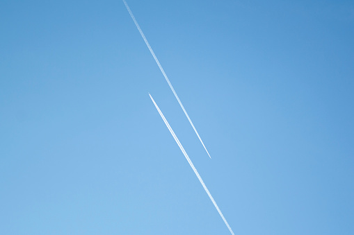 Two airplanes in the blue sky fly to the different ways. Creative concept of relationship. Paths diverged symbol.