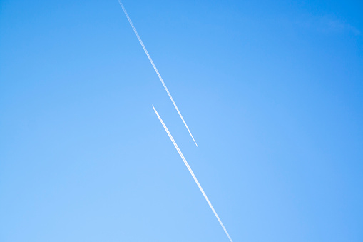 Two airplanes in the blue sky fly to the different ways. Creative concept of relationship. Paths diverged symbol.