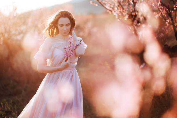 istock Beautiful young girl under the flowering pink tree 1139442969