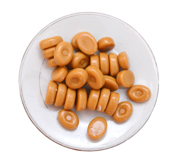 istock caramel candies in plate on white background 1139444007