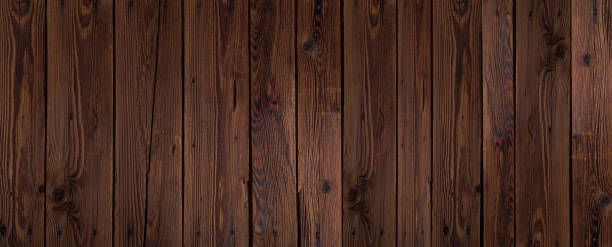 Long wide dark brown lacquered wooden boards texture background. Horizontal panoramic view.