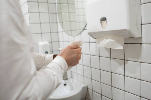 pracownik biurowy bierze ręcznik papierowy po umyciu rąk - paper towel hygiene public restroom cleaning zdjęcia i obrazy z banku zdjęć