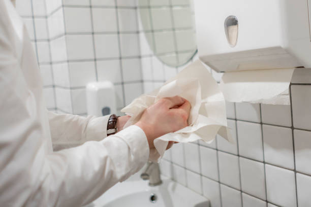 office worker take paper towel after washing his hands stock photo