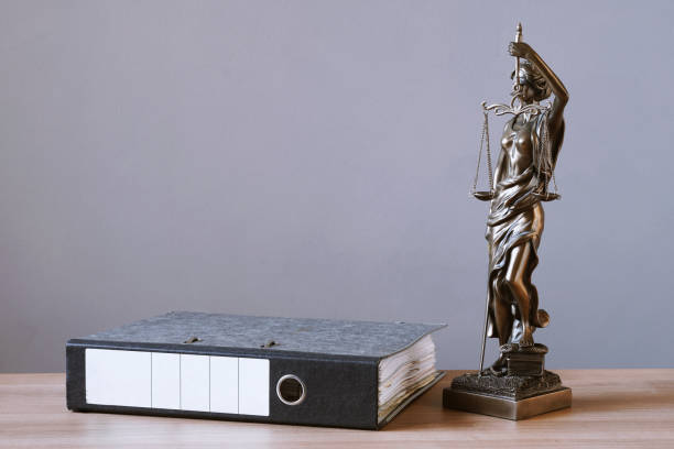 istock lady justice or justitia statue and file folder on desk 1139450799