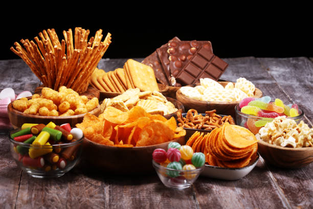 istock Salty snacks. Pretzels, chips, crackers in wooden bowls on table 1139455011