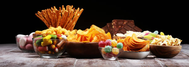 istock Salty snacks. Pretzels, chips, crackers in wooden bowls on table 1139455031