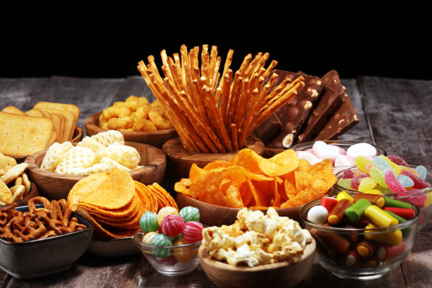 istock Salty snacks. Pretzels, chips, crackers in wooden bowls on table 1139455250