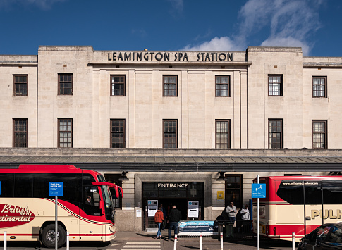 Royal Leamington Spa, United Kingdom - March 17 2019:   Two coaches parked outside the entrance to Leamington Spa railway station on Old Warwick Road