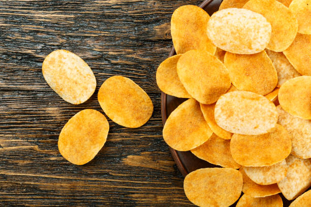 istock potato chips on the black table. unhealthy food. 1139458951