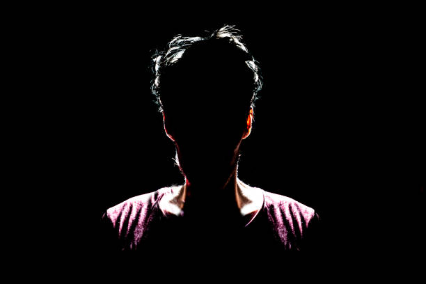 istock silhouette of man in dark place, anonymous backlit contour a 1139459631