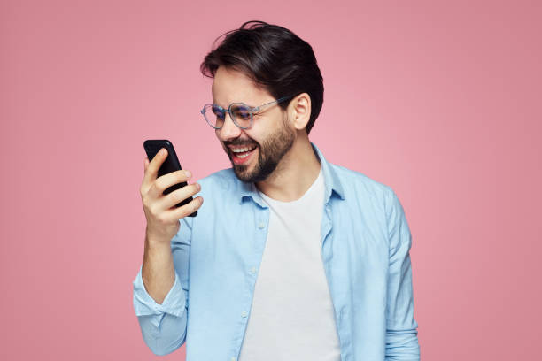 istock Attractive stylish male has happy expression as received pleasant message. Hipster student enjoys online communication. 1139460557