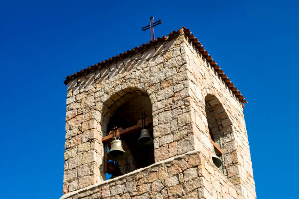 Bell Tower and Bell, Colourful Flags and Blue Sky, the Church of Saint Antonio of Padua in Baia Sardinia, & Blue Sky. Baia Sardinia, Gallura, Sardinia, Italy. - fotografia de stock