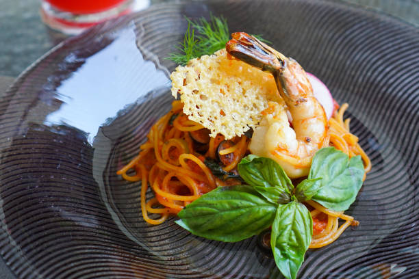 Spaghetti pasta with prawn in creamy tomato sauce Italian food, Spaghetti pasta topping prawn and crispy flour in creamy tomato sauce fusion food stock pictures, royalty-free photos & images