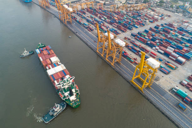 istock Logistics and transportation of Container Cargo ship and Cargo with working crane bridge in shipyard at sunrise, logistic import export and transport industry background 1139462098