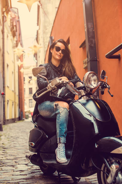 istock Brunette female posing on motor scooter. 1139464835