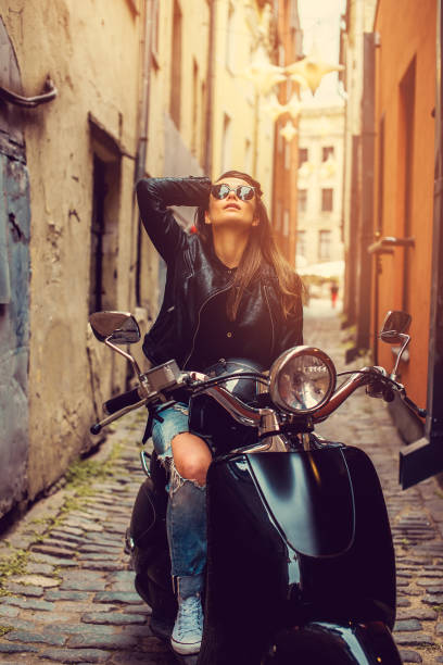 istock Brunette female posing on motor scooter. 1139465009