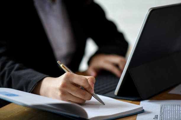 istock Office staff use laptop computer and note in notebook on desk in office. 1139467955