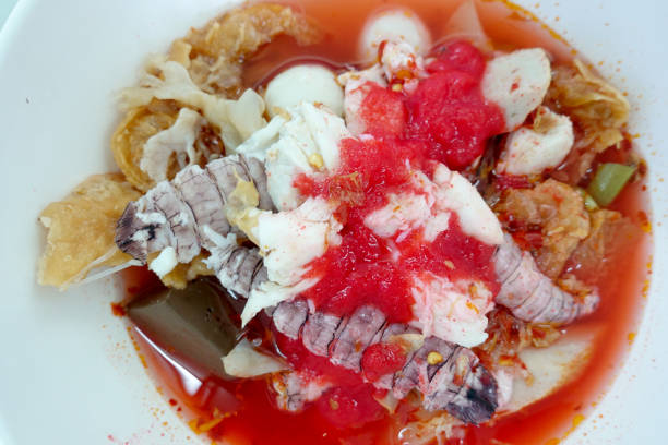 Yentafo Spicy noodle soup,hot and spicy ,with mix seafood, crayfish, shrimp. Asian spicy seafood noodle soup in white bowl on table background. Thai style noodle and street food of Thailand. sopa picante de fideos yentafo, caliente y picante, con mezcla de mariscos, cangrejo de río, camarones. sopa asiática de fideos de marisco picante en un tazón blanco sobre fondo de mesa. fideos de estilo tailandés y comida callejera de tailandia.