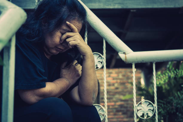 istock The old woman express worried feeling while sitting on stairs 1139470079