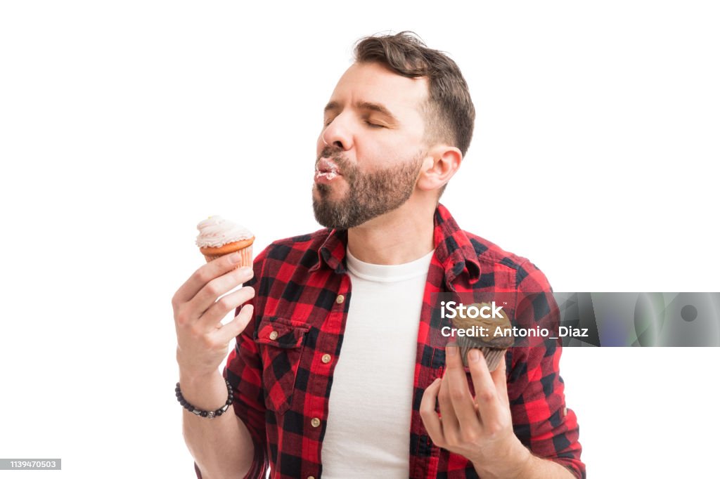 Enjoying Delicious Treats The best feeling in the world is to have creamy and yummy cupcakes Eating Stock Photo